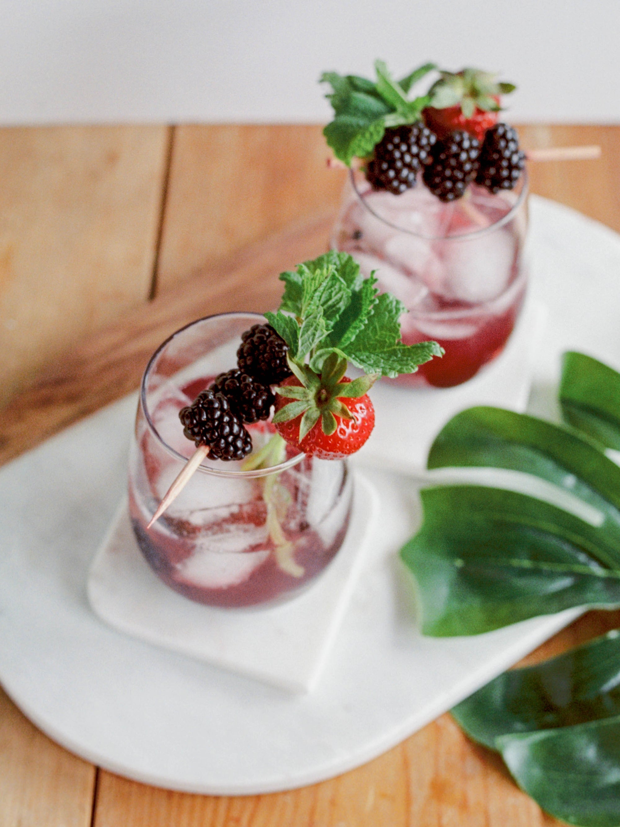 two craft cocktails with blackberries